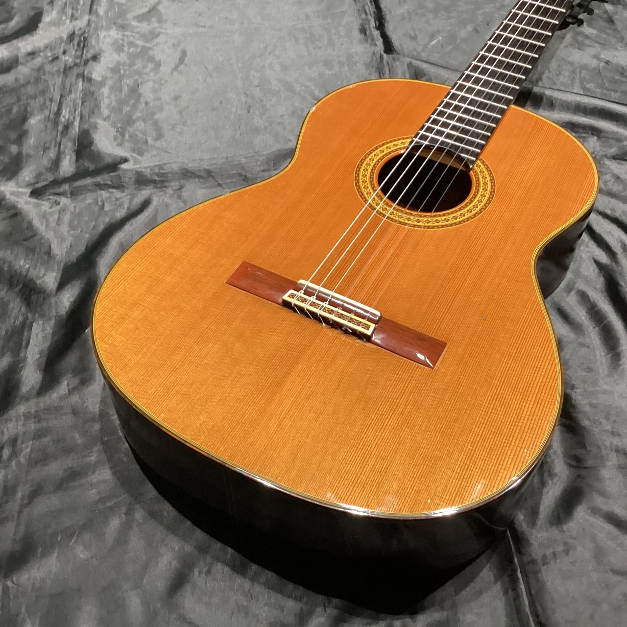 Top-front view of the 松岡良治 M50 acoustic guitar showing the soundhole, bridge, and part of the neck.