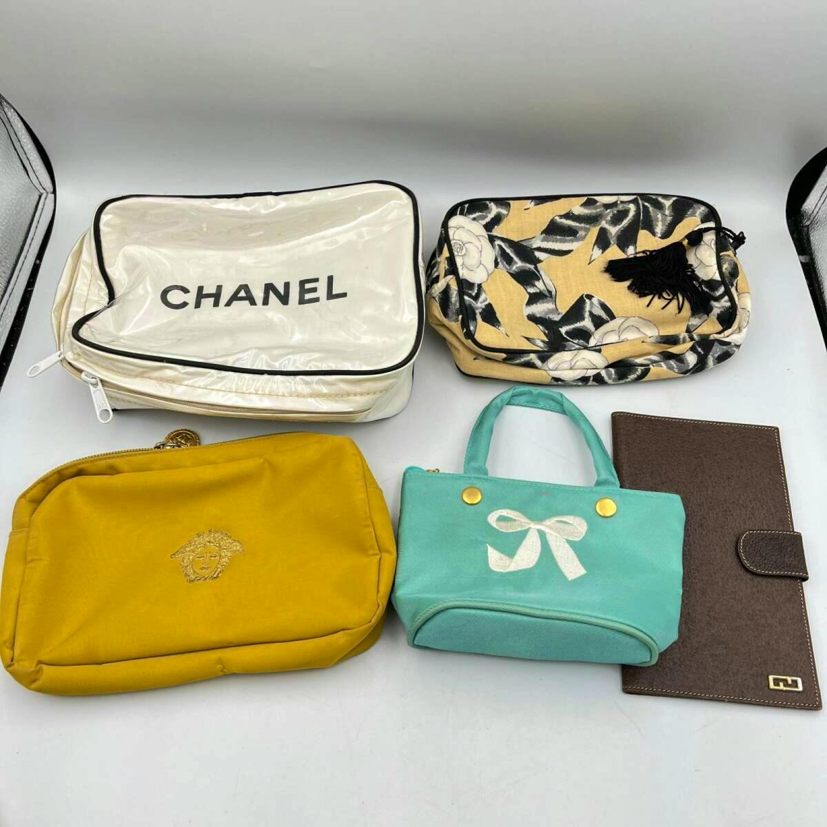 Several small branded pouches and a brown long wallet displayed on a white background.