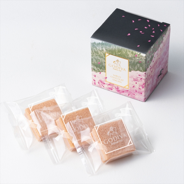 A decorative boxed package and three individually wrapped sakura cookies displayed on a white surface.