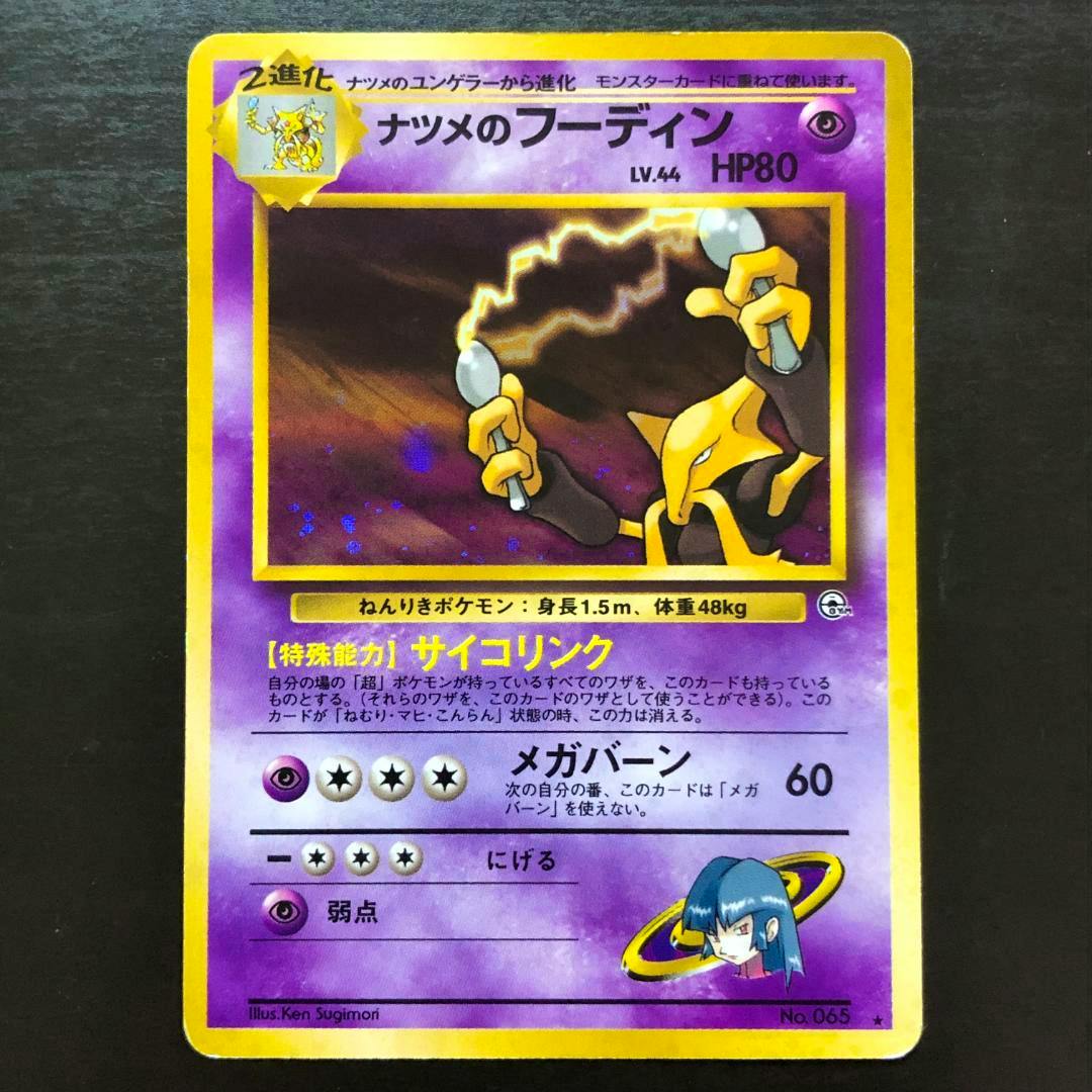 Photo of the front of a Japanese Pokémon trading card (ナツメのフーディン) showing the holographic Alakazam artwork, purple border, and Japanese text.