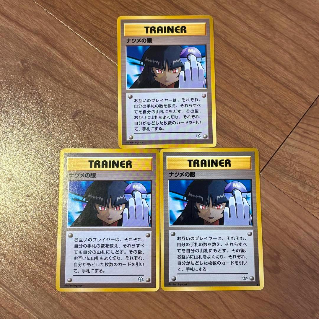 Three Japanese “ナツメの眼” Trainer trading cards (3-card set) laid on a wooden surface.