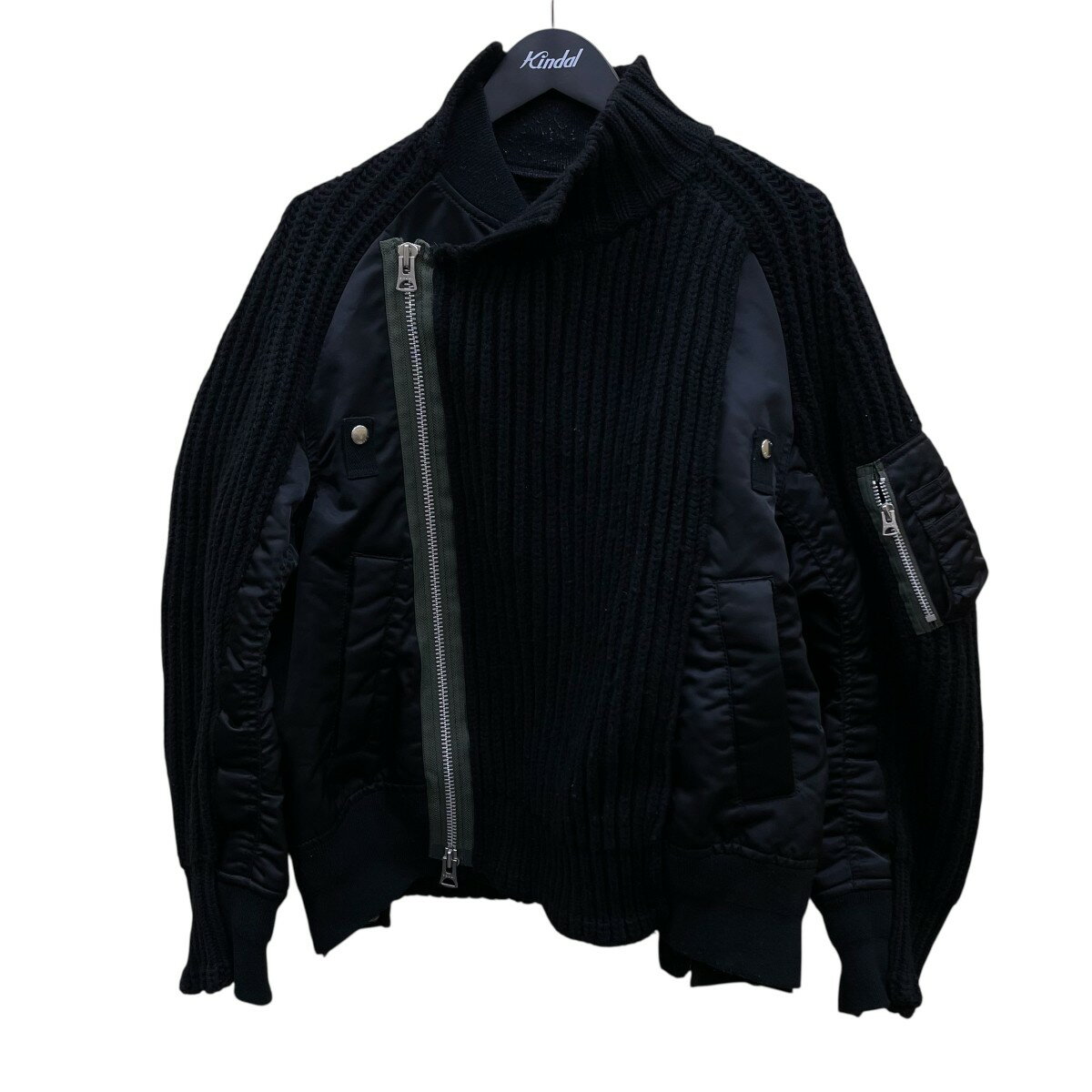 Black sacai nylon twill mix knit blouson (men's jacket) hanging on a hanger, front view showing diagonal zipper and knit and nylon panel details.