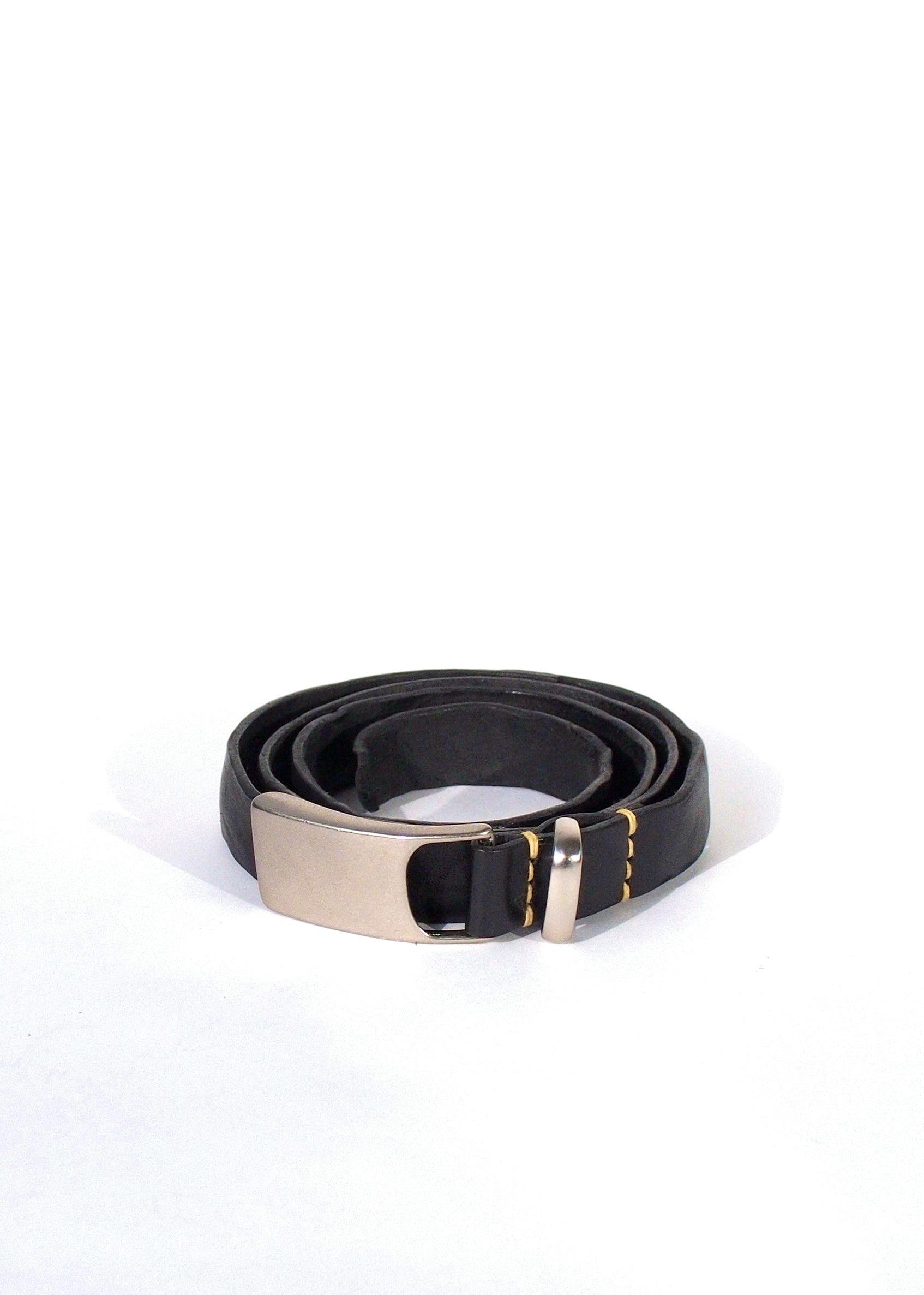 Coiled cow-suede belt with a metal buckle shown on a white background.