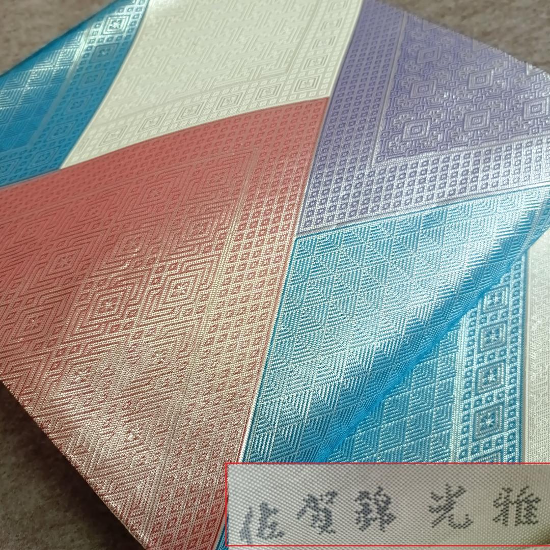 Obi for kimono showing colorful woven sections with sa‑yagata geometric pattern in blue, purple, red, and ivory.