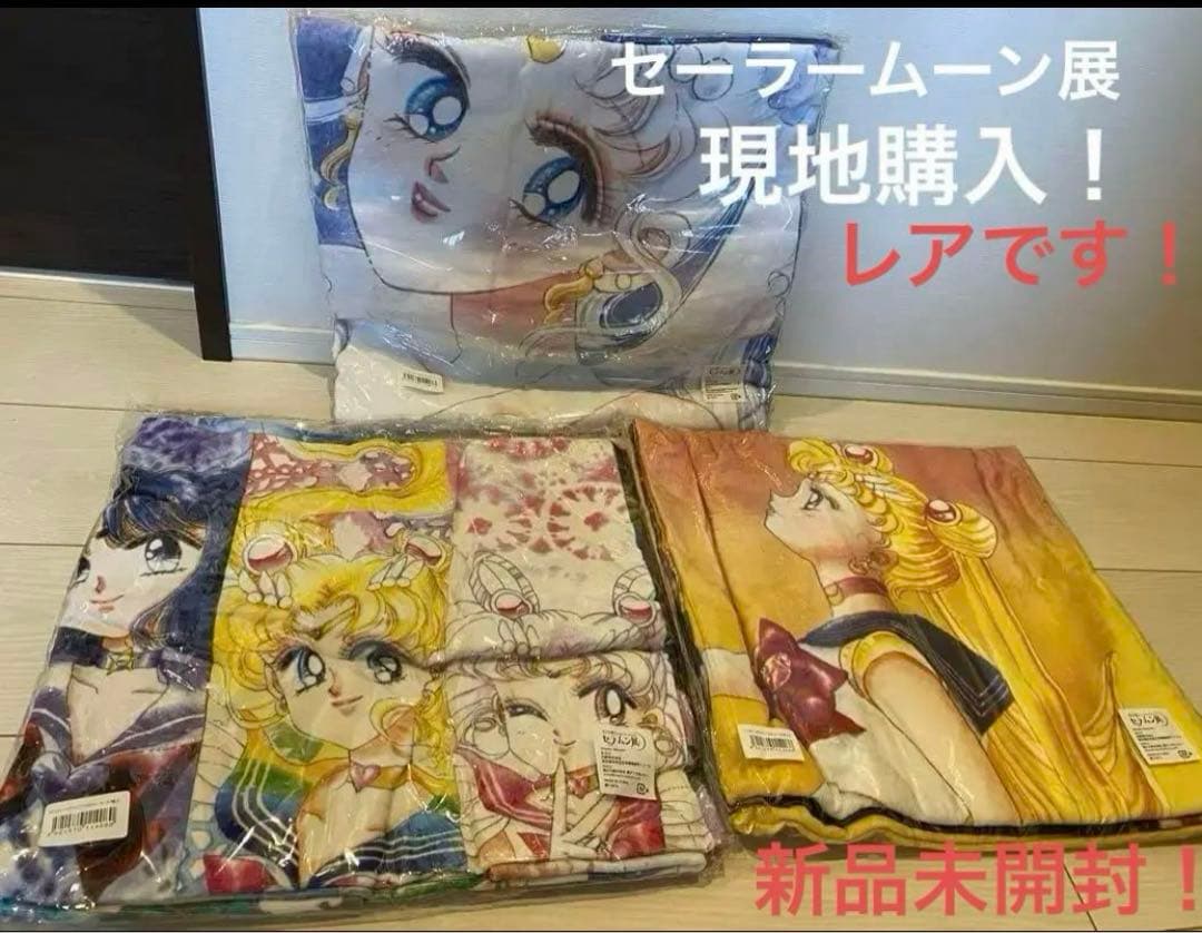 Three sealed Sailor Moon exhibition wide bath towels with character prints shown on a floor.