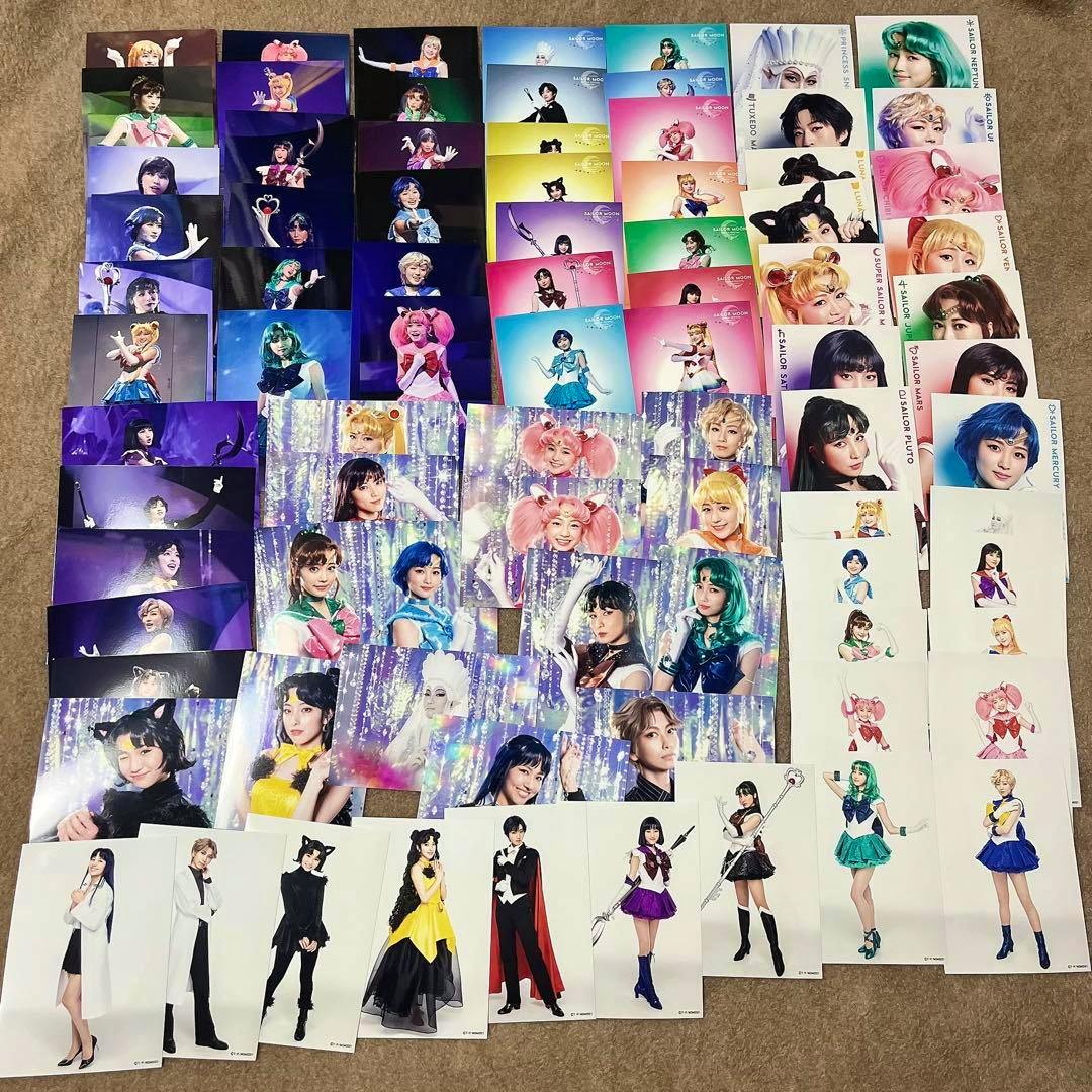 Multiple Sailor Moon musical bromide photographs and portrait prints arranged on a floor surface.
