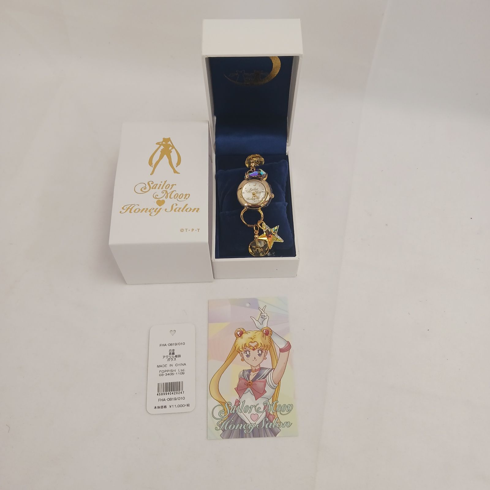Sailor Moon Honey Salon wristwatch with star charm displayed in an open box alongside a tag and illustrated character card.