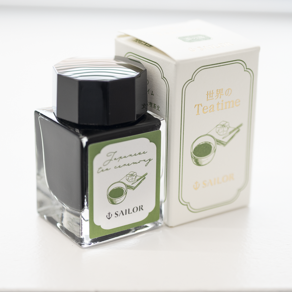 A Sailor fountain pen ink bottle alongside its box, showing a green tea–themed label.