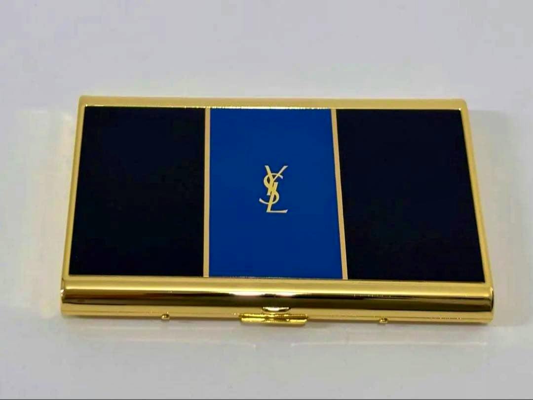 Gold-trimmed Yves Saint Laurent card case with black side panels and a blue center panel displaying the YSL logo.