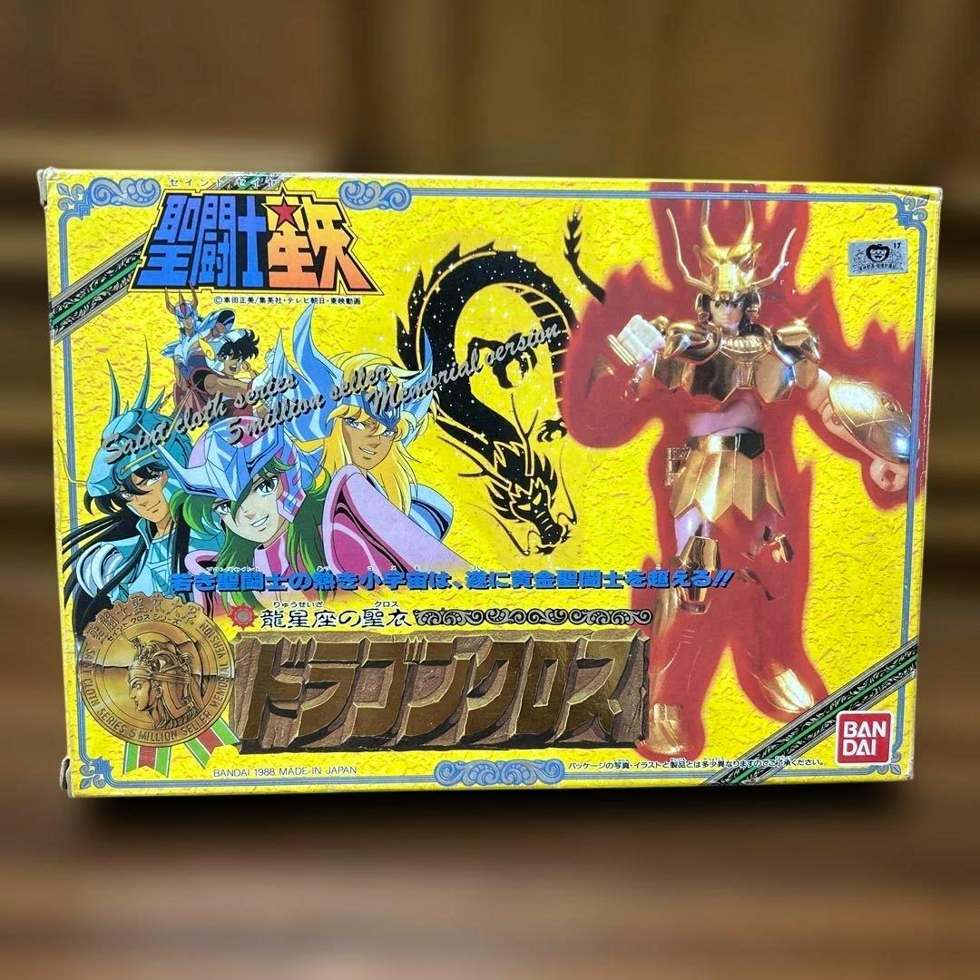 Front of the 聖闘士星矢 ゴールドドラゴンクロス メモリアル版 box showing artwork and a photo of the gold-armored figure.
