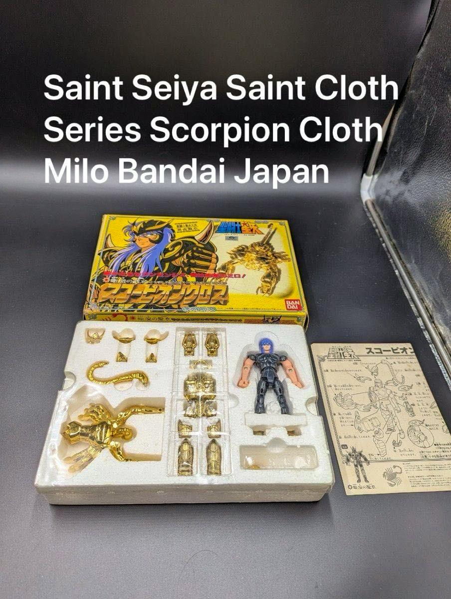 Saint Seiya Scorpion Cloth boxed set showing gold armor parts, a plastic figure, and instruction sheet in a foam tray.