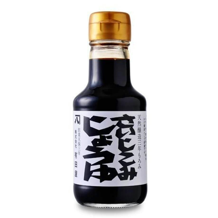 A bottle of さいしこみしょうゆ (soy sauce) with a white label featuring Japanese characters and a gold cap.