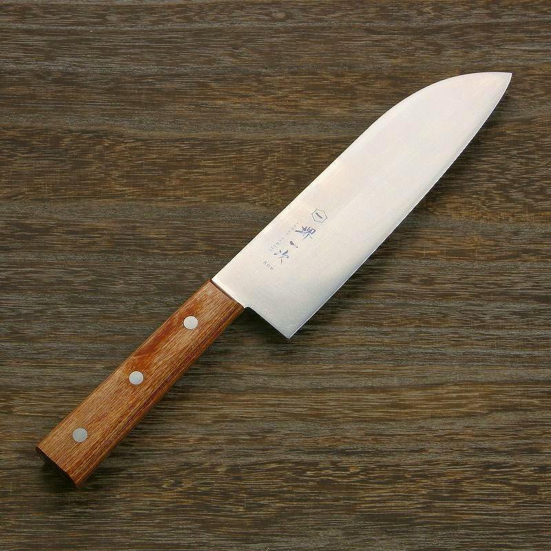 Santoku (chef) knife with a stainless steel blade and a wooden handle lying on a wood surface.
