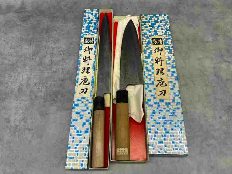 Two Japanese chef knives (sashimi/deba styles) with wooden handles shown in their boxes.