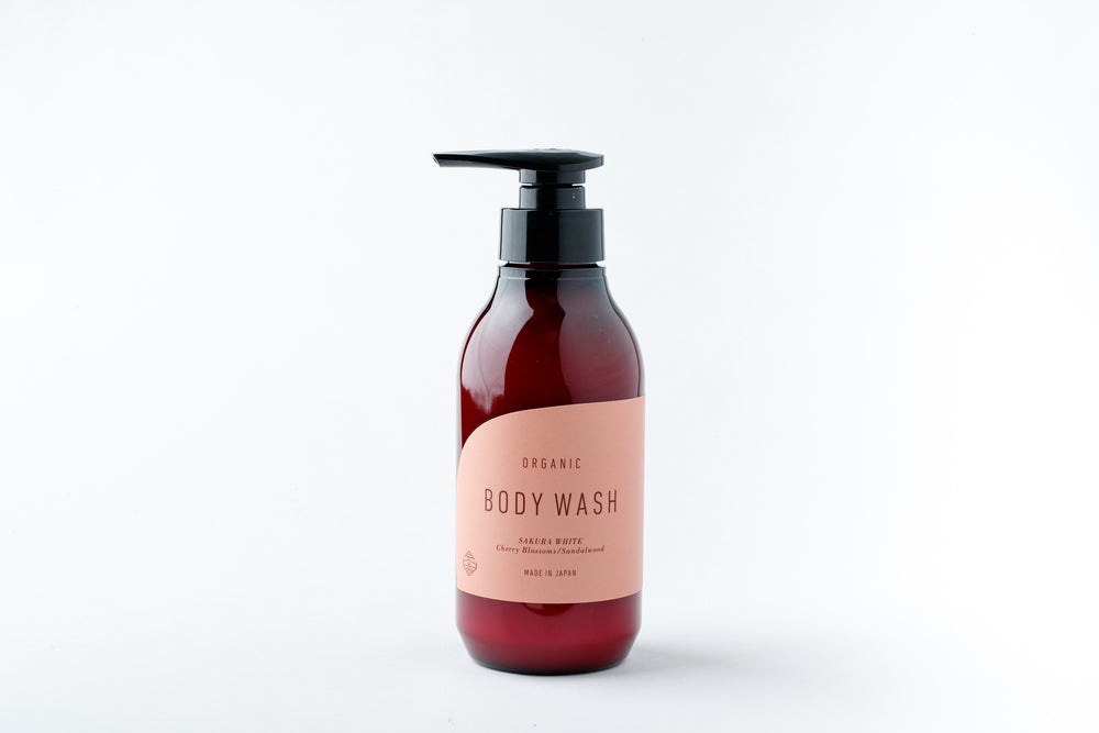 A pump bottle of SAKURA WHITE BODY WASH＆ BODY GEL with a pink label on a white background.