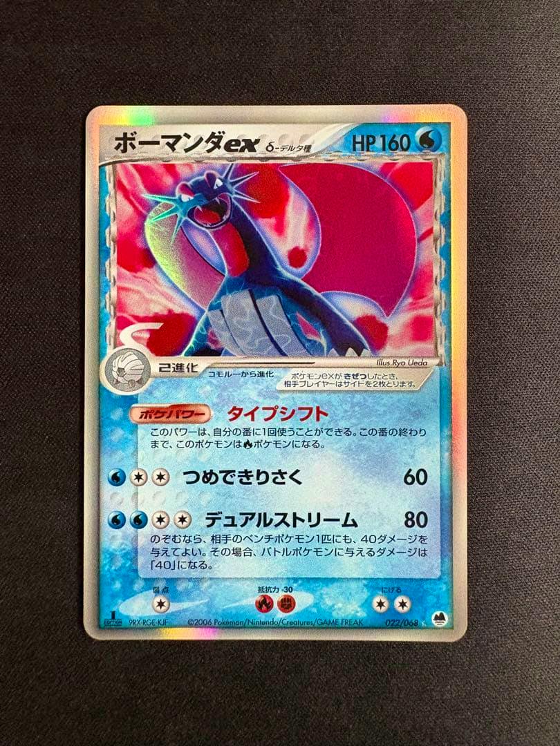 Full front of the Japanese trading card ボーマンダex (022/068) photographed on a dark textured background.