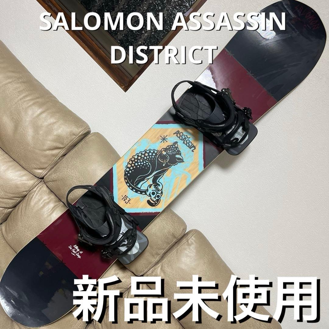 Top view of a Salomon Assassin snowboard with mounted bindings resting on a couch.
