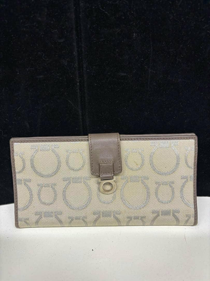 Front view of the Salvatore Ferragamo canvas long wallet showing the Gancini pattern and leather tab closure.