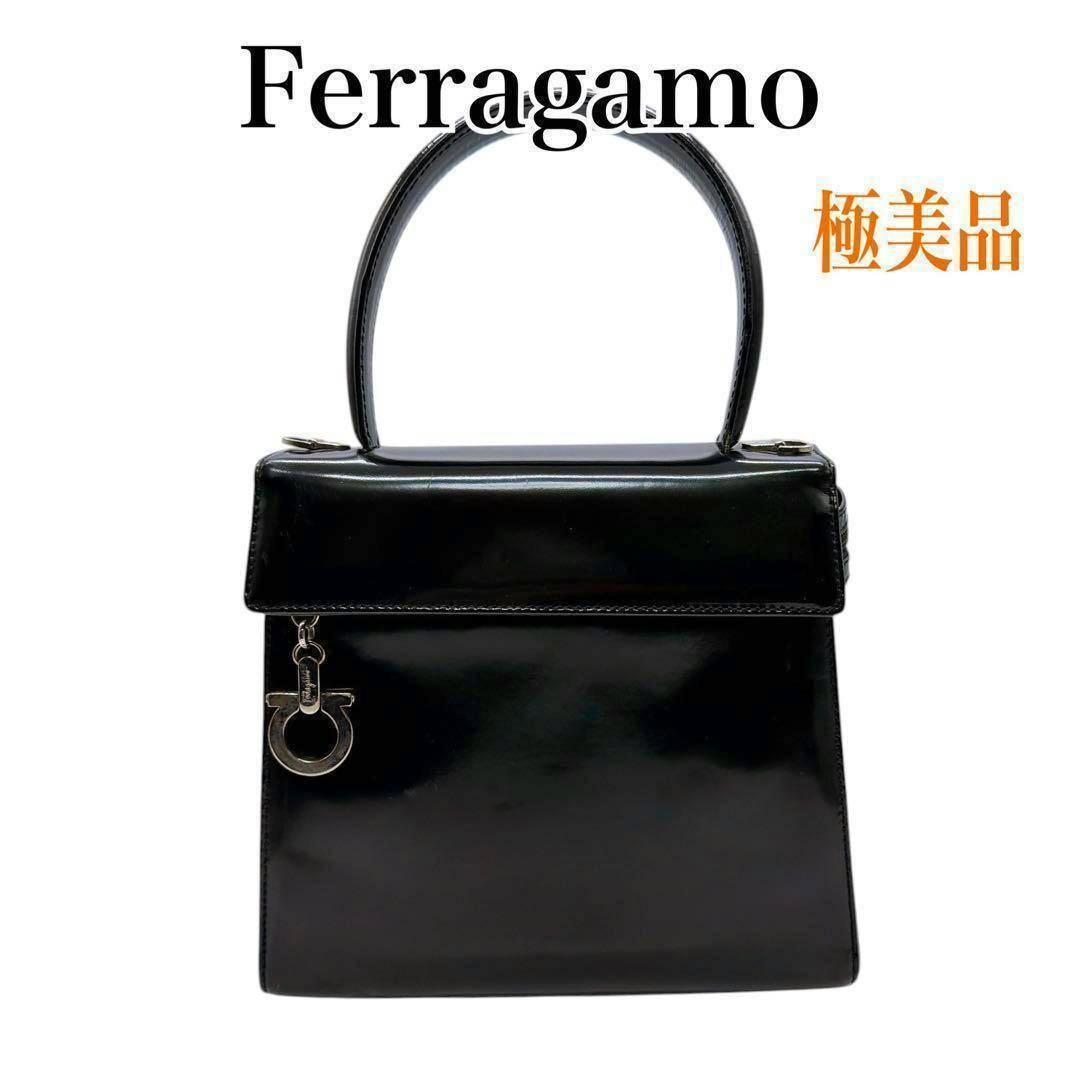 Front view of a black Ferragamo top-handle handbag with a Gancini charm.