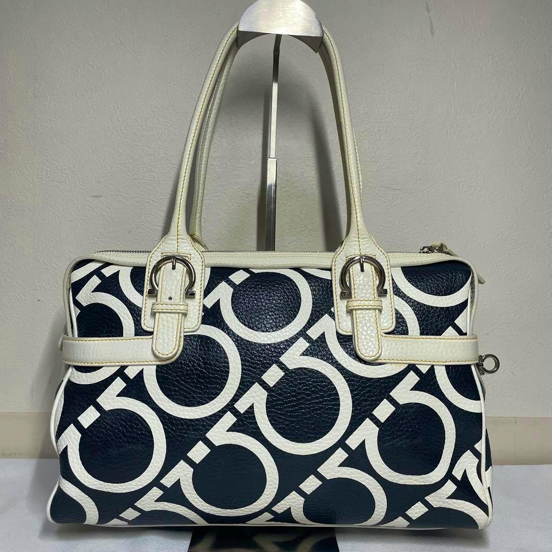 Front view of a Ferragamo tote/boston bag with a navy and white Gancini pattern and white leather handles.