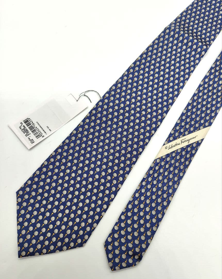 Blue Salvatore Ferragamo men's silk necktie with a golf-pattern motif and attached tag laid flat on a white background.