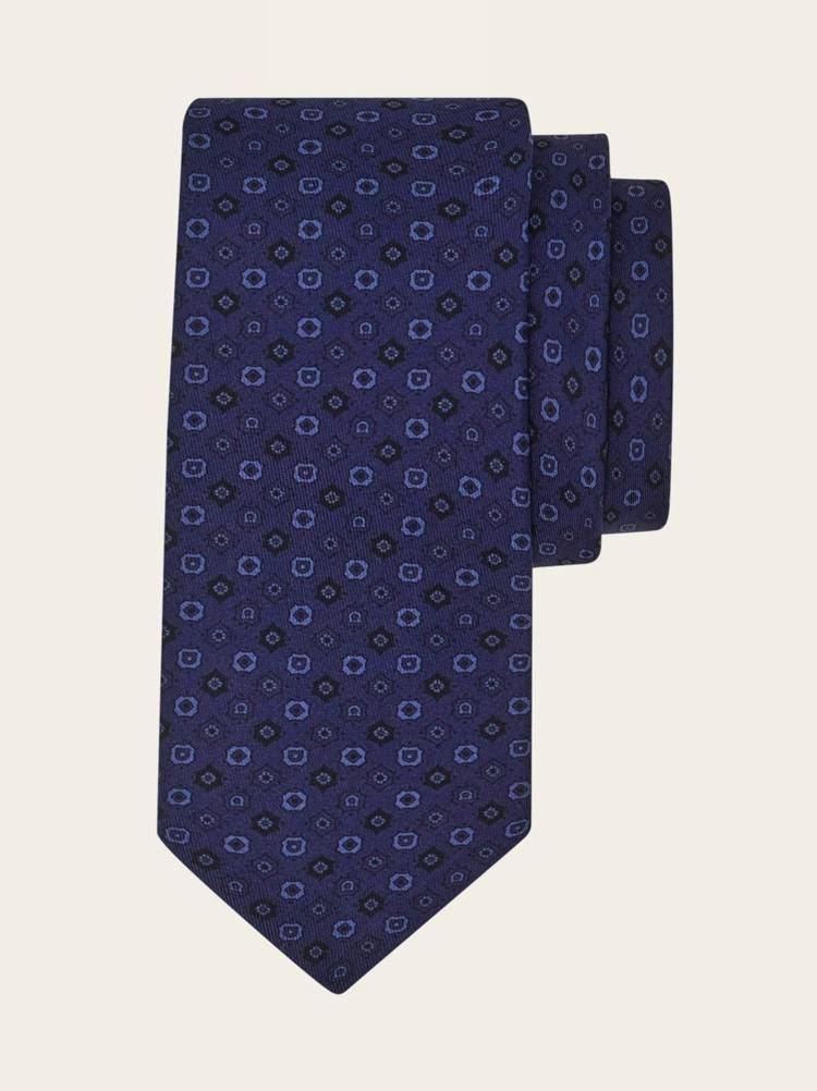 A navy silk necktie with a micro Gancini-style geometric print shown folded on a neutral background.