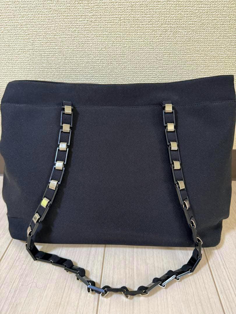 Front view of a black Salvatore Ferragamo canvas Vara chain bag with a metal-accented chain shoulder strap.