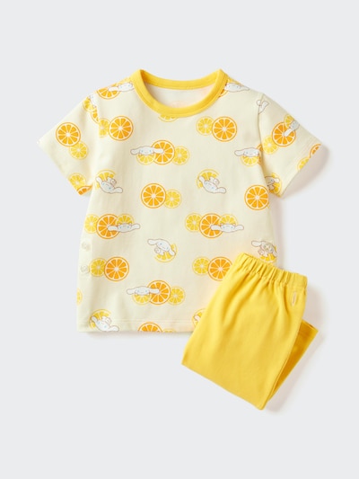 Children's yellow short-sleeve cotton pajama set with citrus and Sanrio character print shown flat with matching yellow pants.