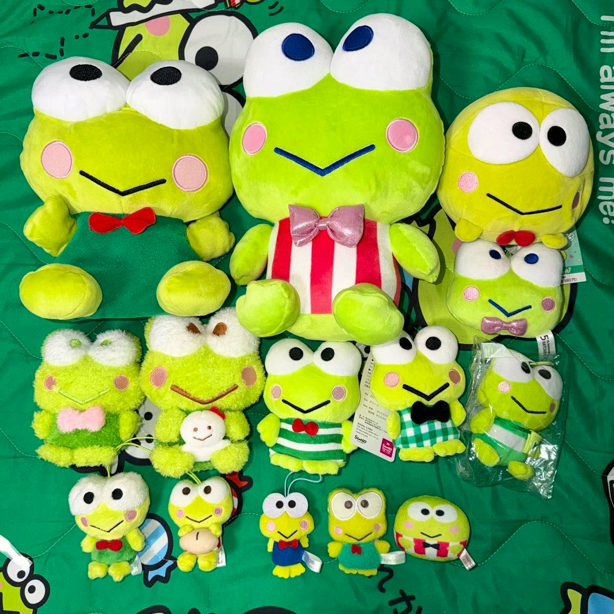 Many Sanrio Keroppi frog plush toys and mascots arranged on a green surface.
