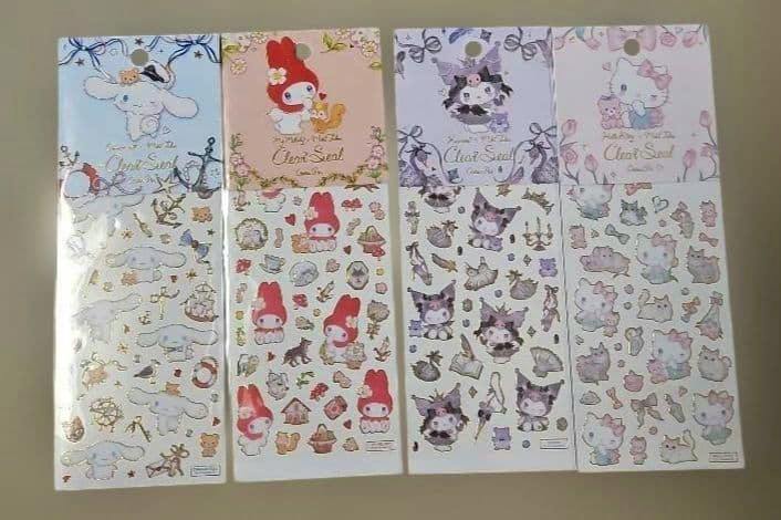 Four clear sticker sheets from the Sanrio×たけいみき set displayed side by side, showing character designs and decorative headers.