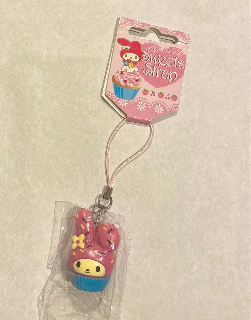 Front view of the My Melody cupcake plastic charm attached to its pink "Sweets Strap" display card.