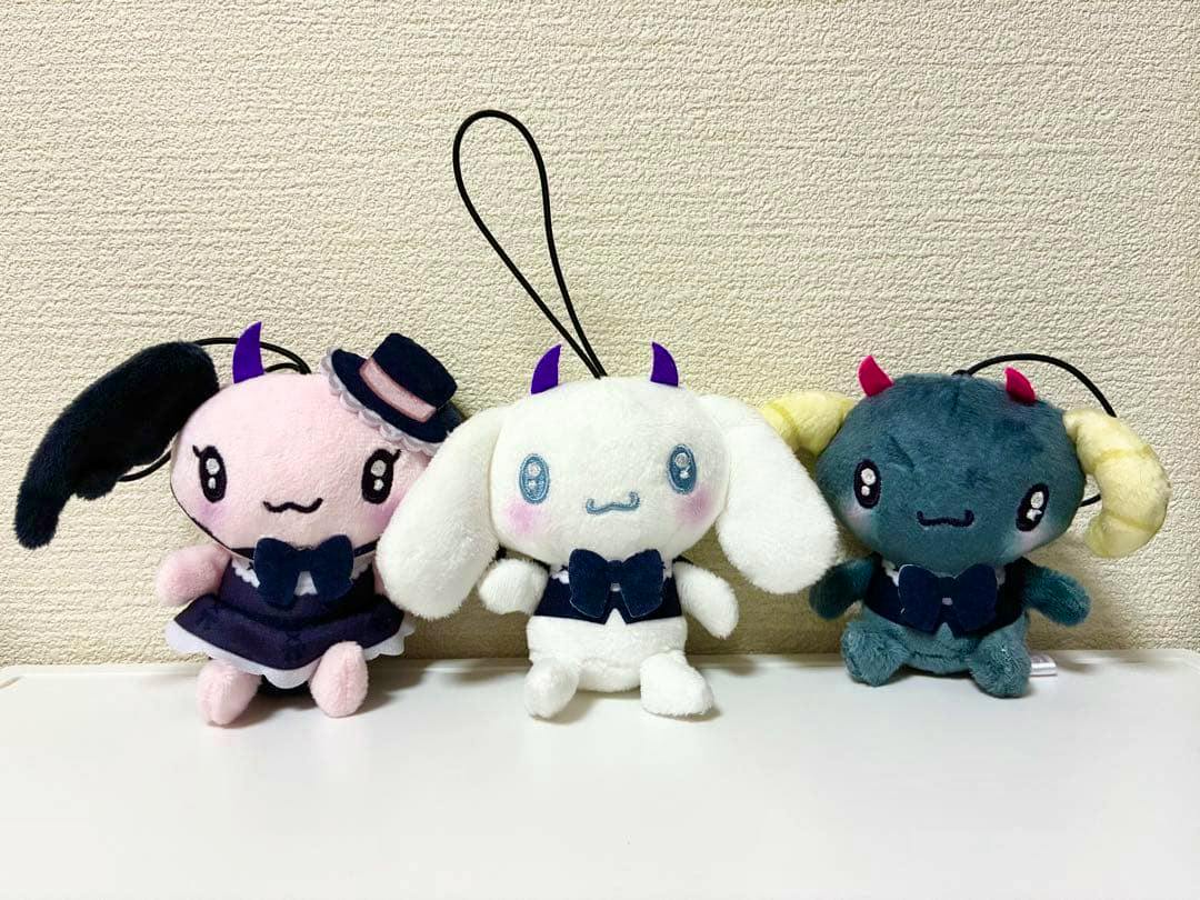 Three Sanrio Neo Gothic Devils Cinnamoroll plush toys (pink, white, and teal) shown side by side on a surface.