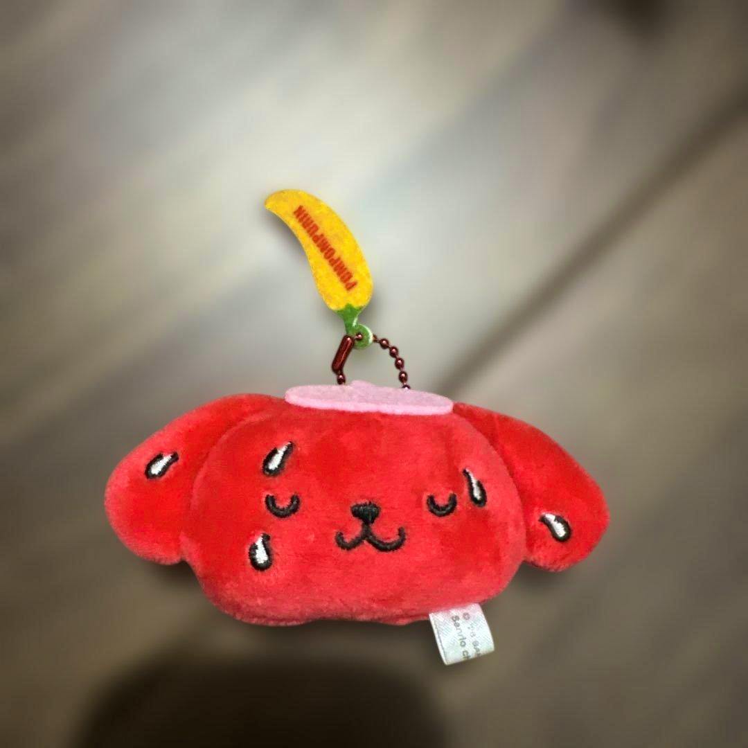 Front-facing red Pompompurin plush keychain with embroidered face, teardrop sweat details, and a banana-shaped tag.