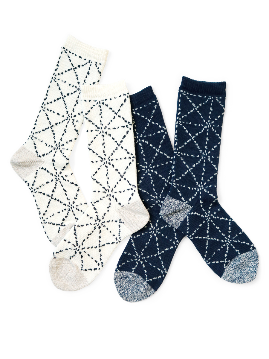 Two pairs of men's SASHIKO patterned cotton socks, one white pair and one navy pair, laid flat on a white background.