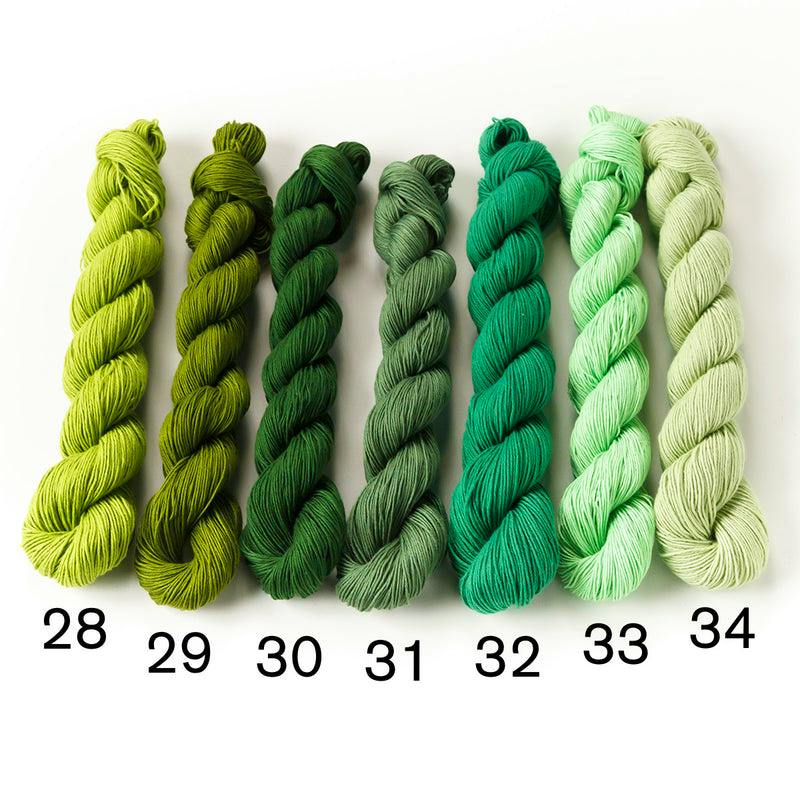 Seven skeins of green cotton sashiko thread numbered 28 to 34 laid side by side on a white background.