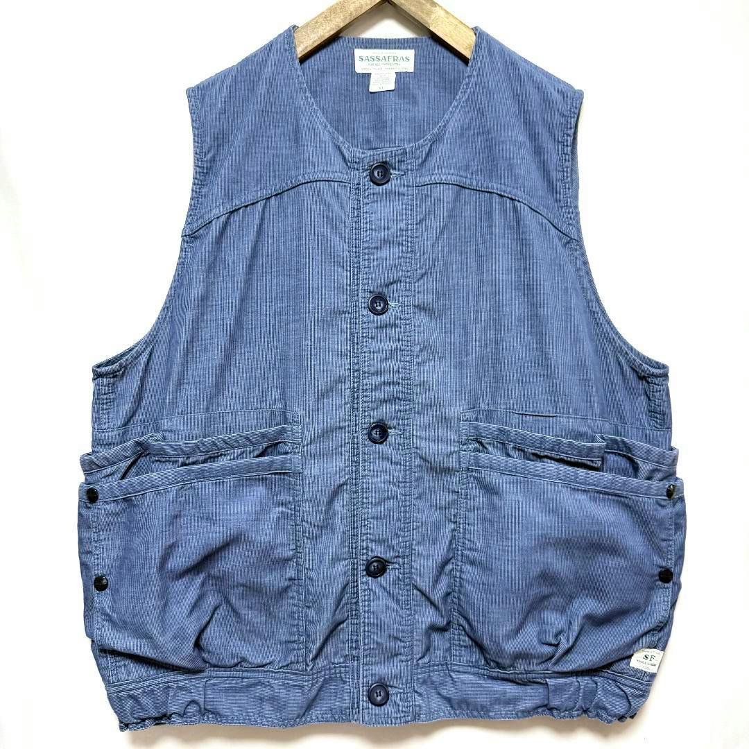 Front view of a blue SASSAFRAS XL corduroy overgrown hiker vest with button closure and large front pockets on a hanger.