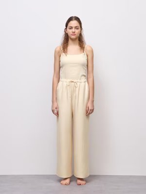 Front view of a model wearing beige satin easy pants and a camisole.