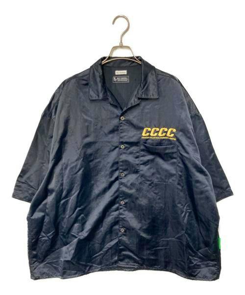 Navy satin open-collar men's shirt pictured front-on on a hanger, showing button closure and a yellow "CCCC" logo on the chest.