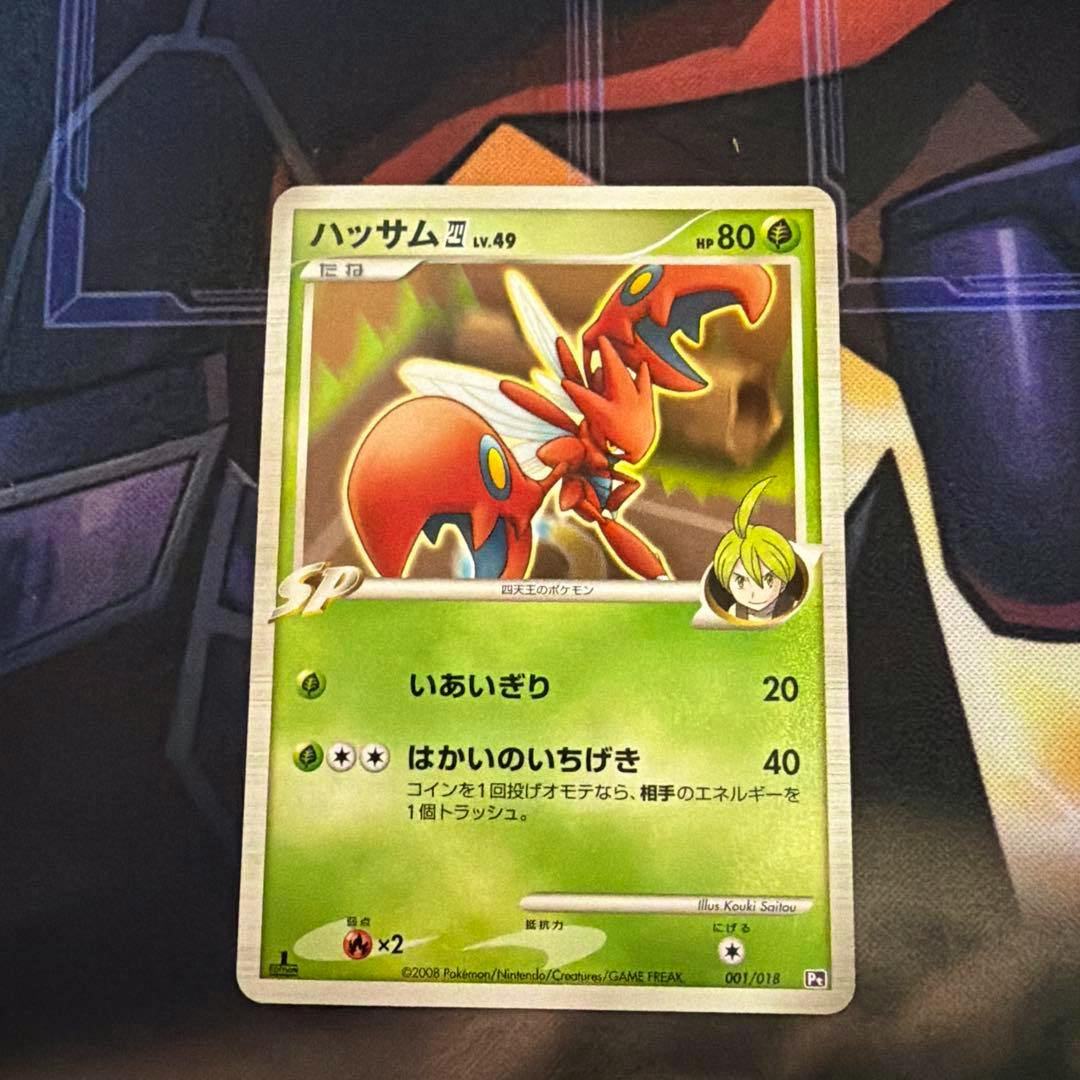 Front of the Japanese ハッサム trading card photographed on a playmat, showing the full card artwork, Japanese text, and HP 80.