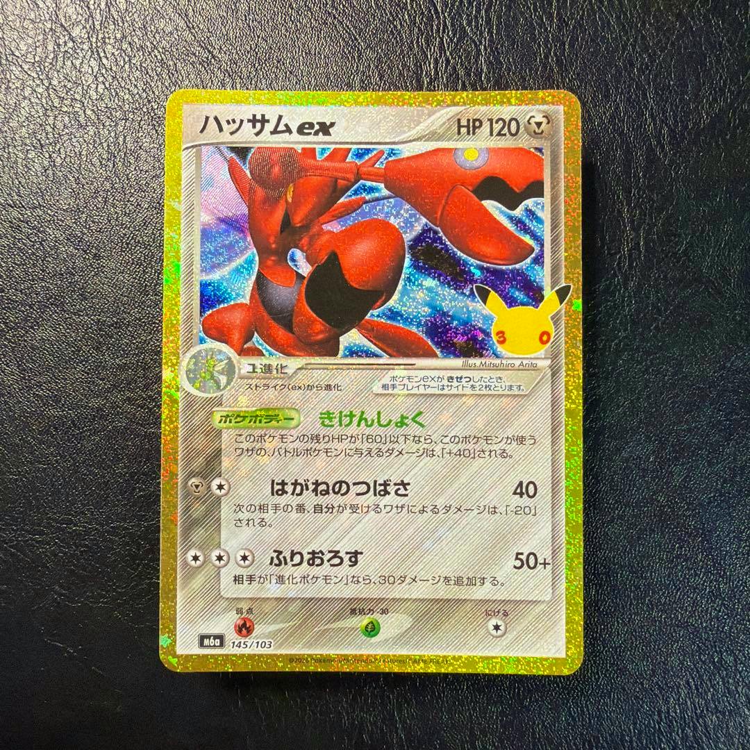 Photograph of the front of the ハッサムex 30th 145/103 trading card showing the Scizor (ハッサムex) artwork and Japanese text on a holographic foil card.
