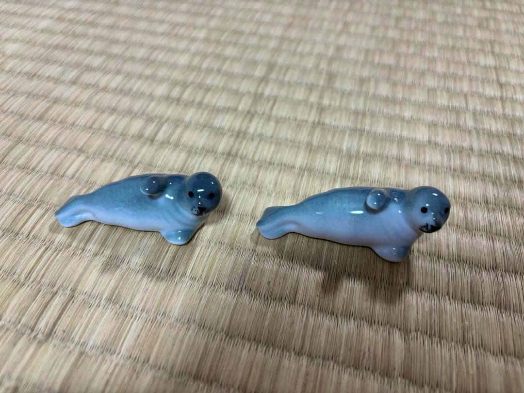 Two seal-shaped ceramic chopstick rests placed on a tatami mat.
