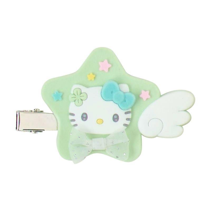 Close-up of a green star-shaped hair clip with a white cartoon cat face, attached metal clip, a white wing, and a small bow.