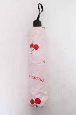 Folded pink cherry-patterned folding umbrella in its sleeve with a carrying strap.