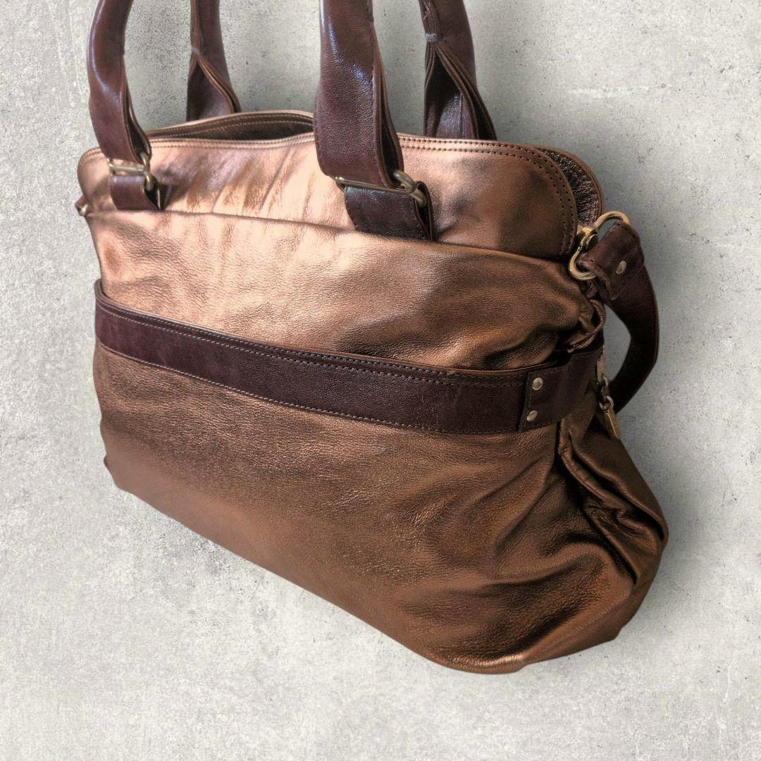 Brown leather See by Chloé 2-way handbag with top handles and a shoulder strap shown from a side/back angle.