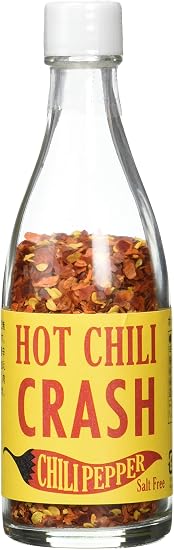 Clear glass bottle of Seeds Core Hot Chicken Crush Chili showing crushed red chili flakes and a yellow product label.