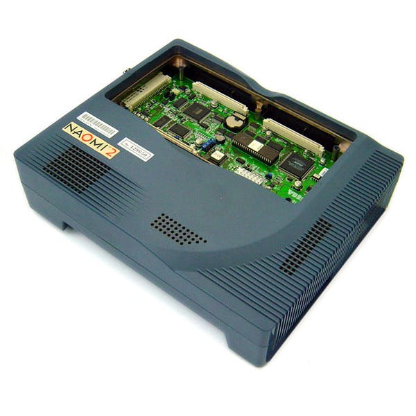 Top-down view of the NAOMI 2 motherboard visible through a blue plastic system enclosure.