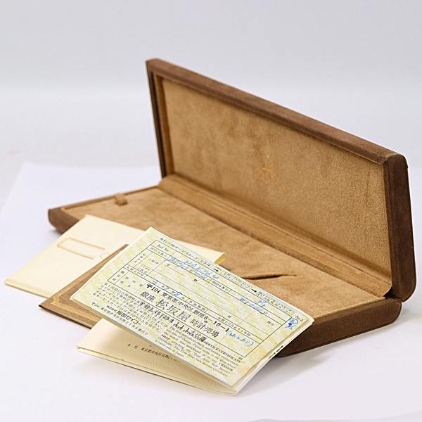 Open brown Seiko Credor watch box (empty) with warranty papers and documents displayed.