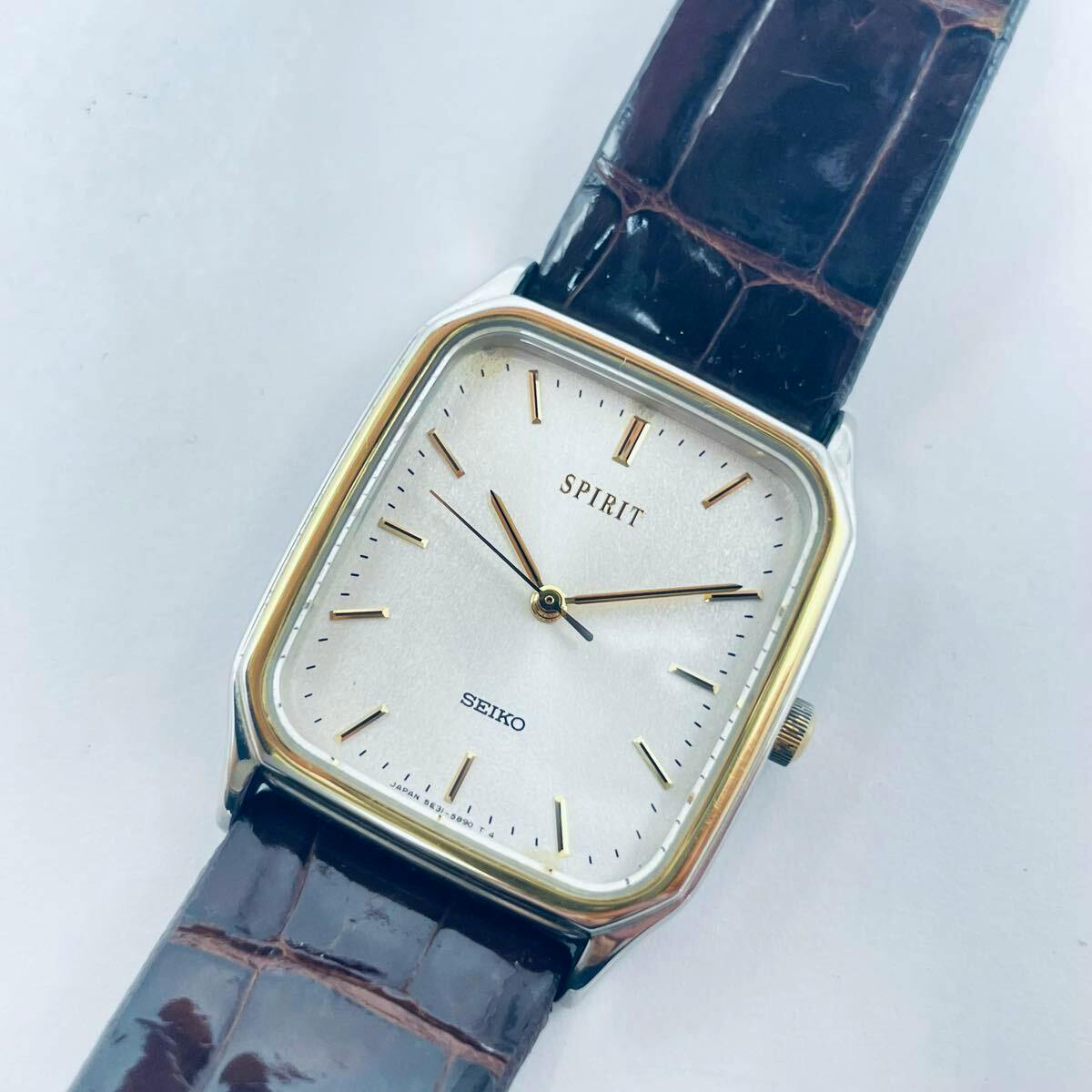 Square Seiko SPIRIT quartz wristwatch with a silver dial, gold-tone hands and indices, and a dark brown leather strap.