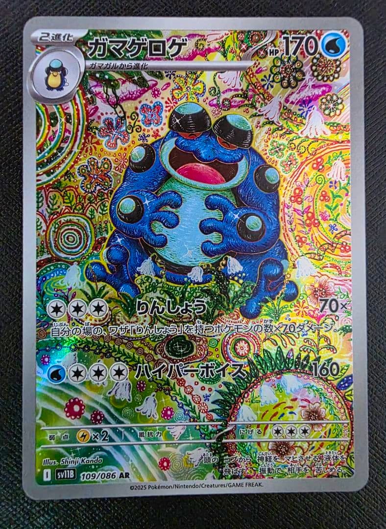 Photo of the trading card ガマゲロゲ AR SV11B ブラックボルト 109/086 showing the card front placed on a dark textured background.