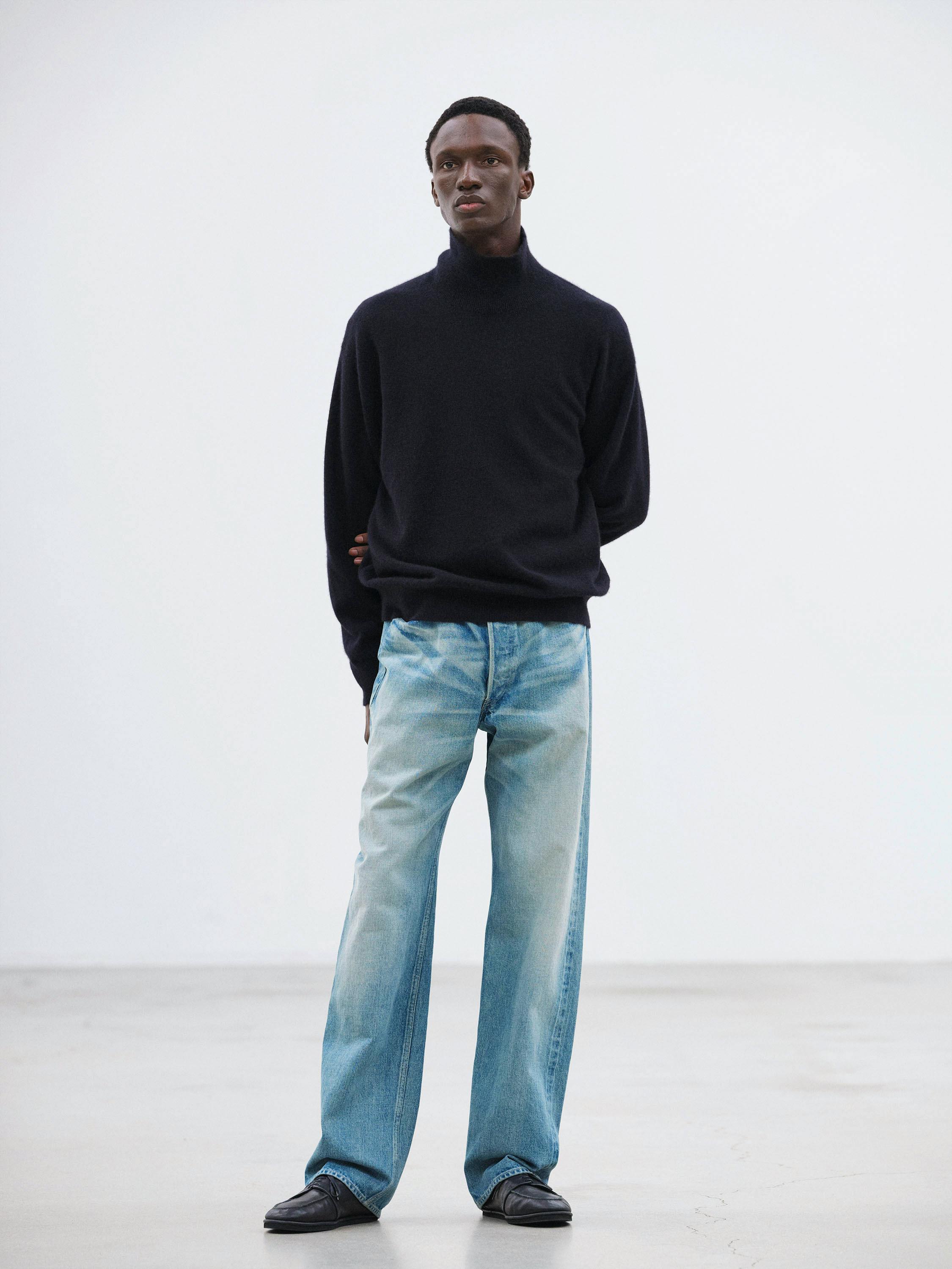 Front full-length view of a male model wearing the selvedge faded heavy denim wide pants.
